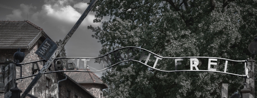 The entrance gate to Auschwitz concentration camp with the infamous "Arbeit Macht Frei" sign, a stark reminder of the horrors of the Holocaust.