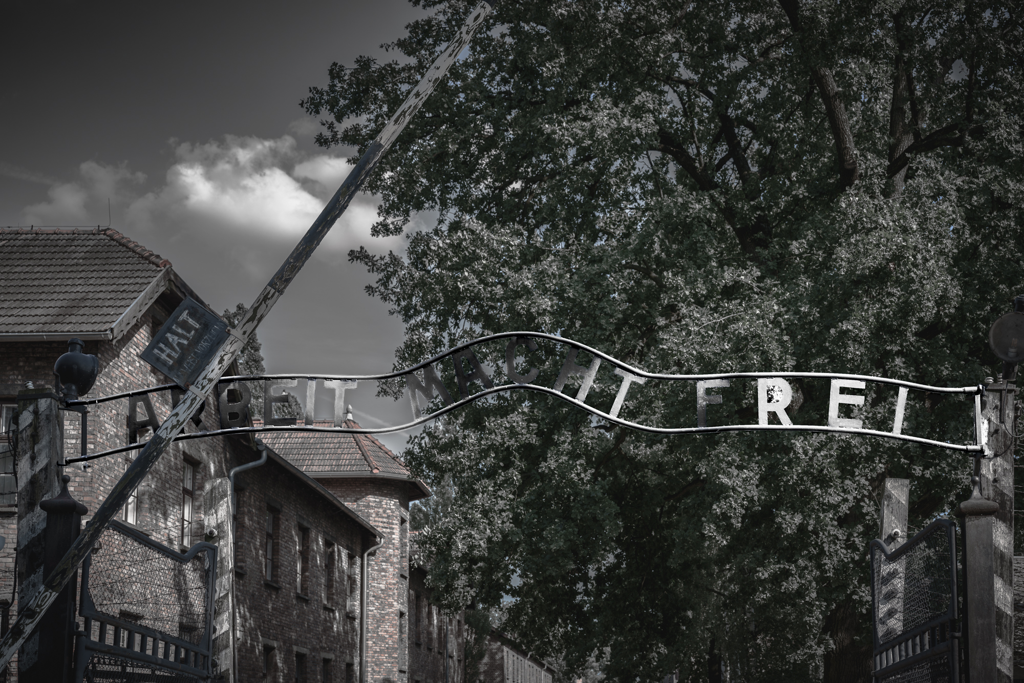 The entrance gate to Auschwitz concentration camp with the infamous "Arbeit Macht Frei" sign, a stark reminder of the horrors of the Holocaust.