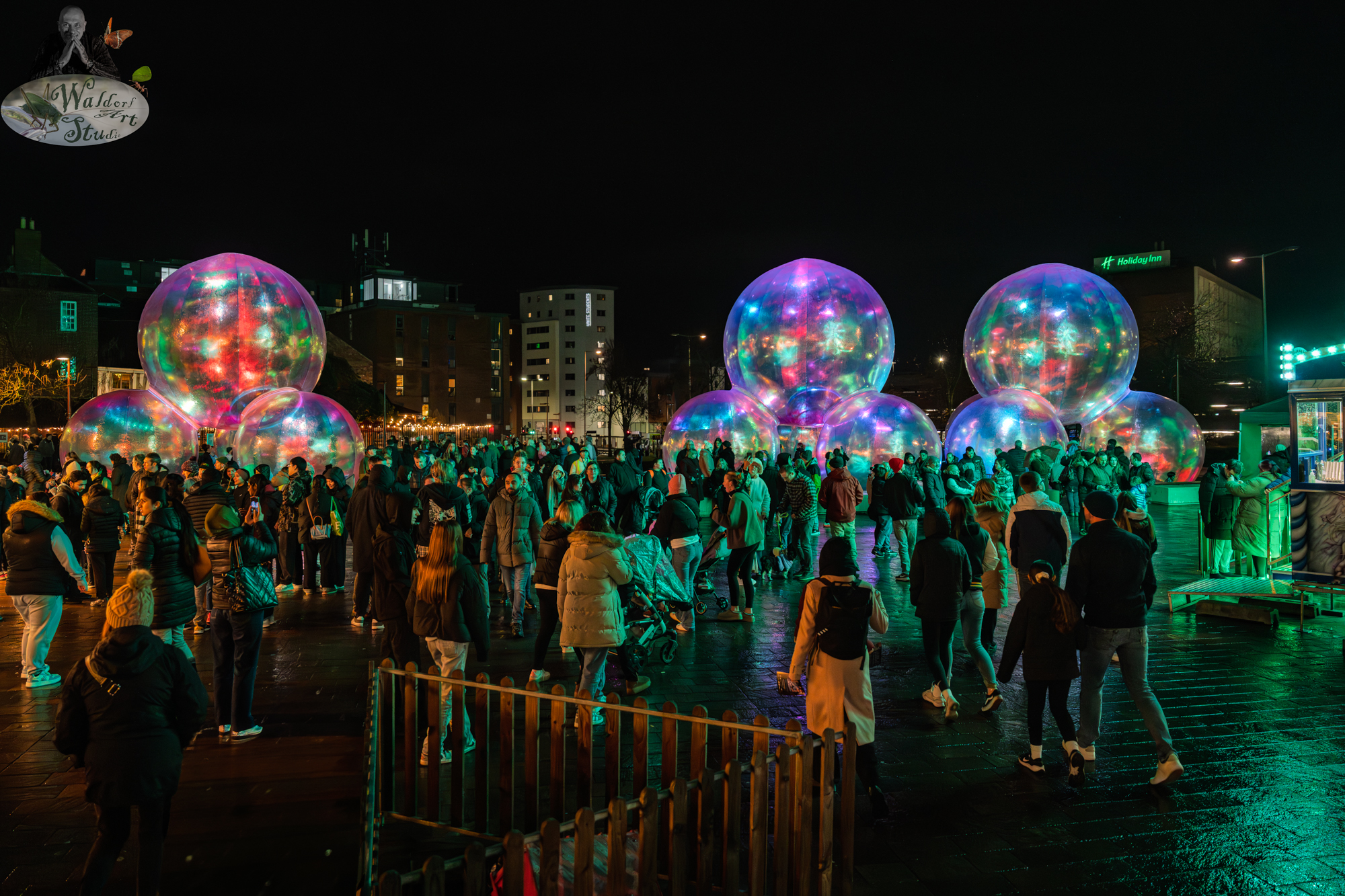 Illuminated spheres glowing in vibrant colours at Light Up Leicester 2025, drawing a crowd into the mesmerising display.
