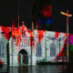 St. Mary de Castro Church illuminated with vibrant red and multicolor projections during Light Up Leicester 2025, creating a mesmerizing fusion of history and modern digital art.