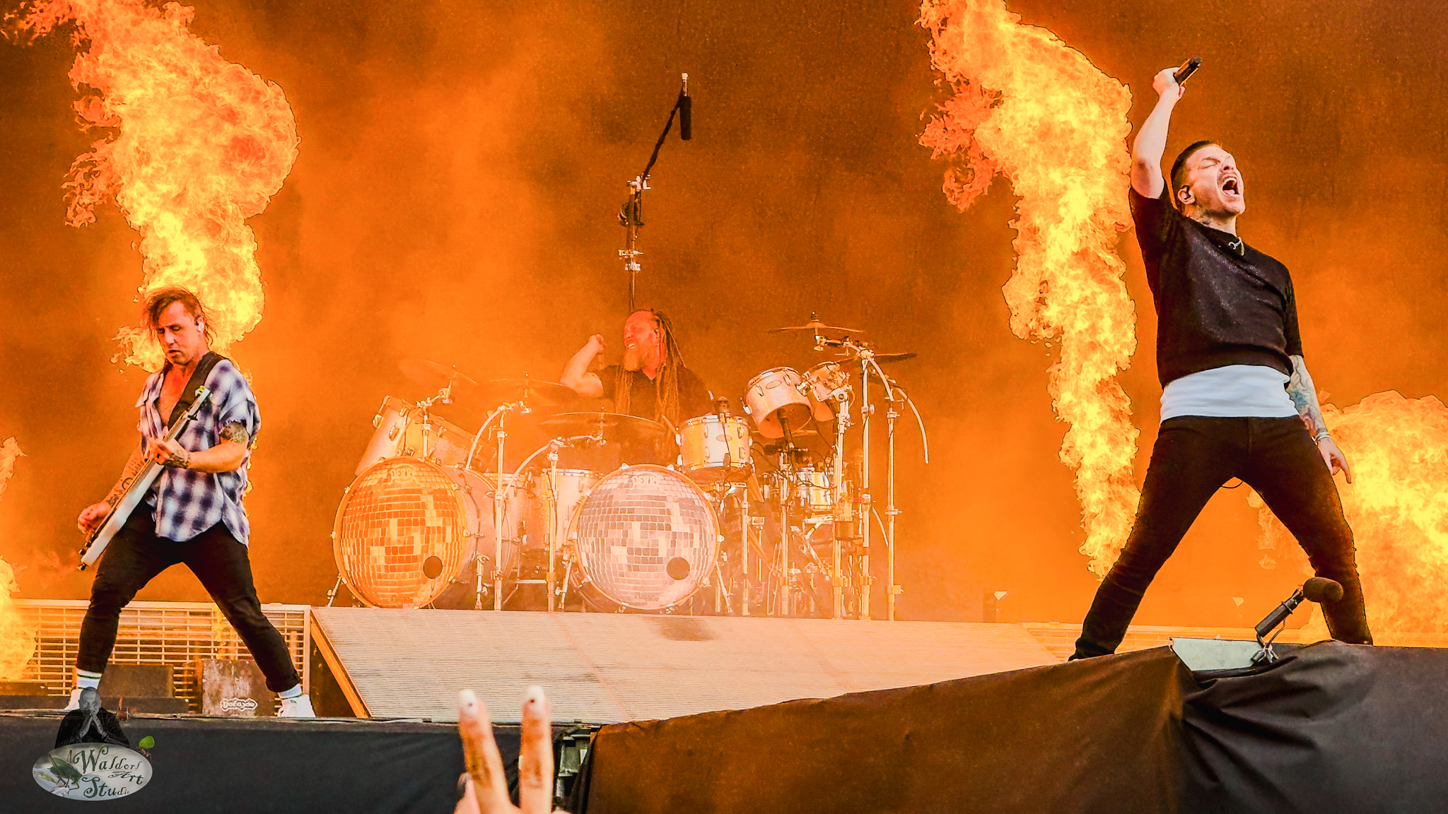 Brent Smith, Zach Myers i Barry Kerch of Shinedown deliver a blazing performance at Download Festival 2025, surrounded by dramatic flames and thunderous drums.