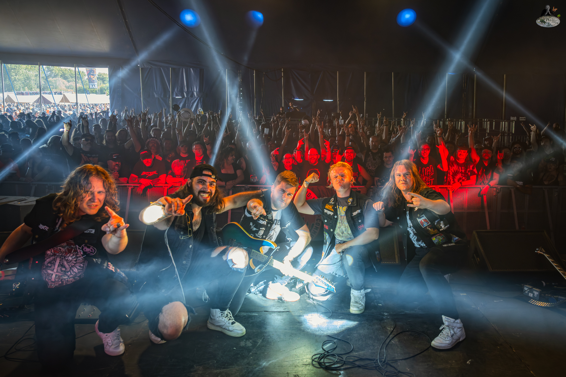 Rascal posing with the crowd after their Bloodstock 2025 performance, beams of stage light shining over the scene.