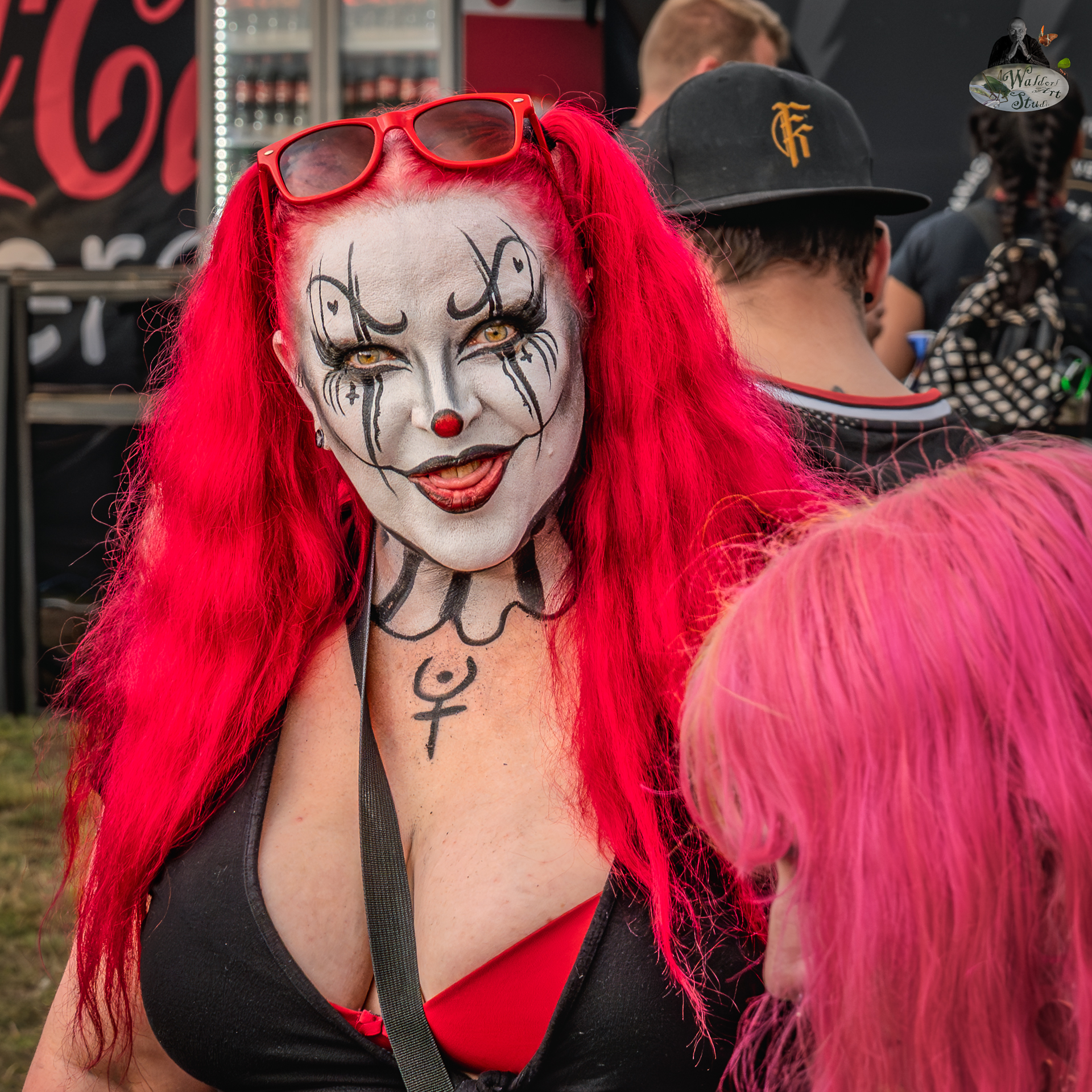 Festival-goer with red hair and dramatic clown face paint at Bloodstock Open Air 2025