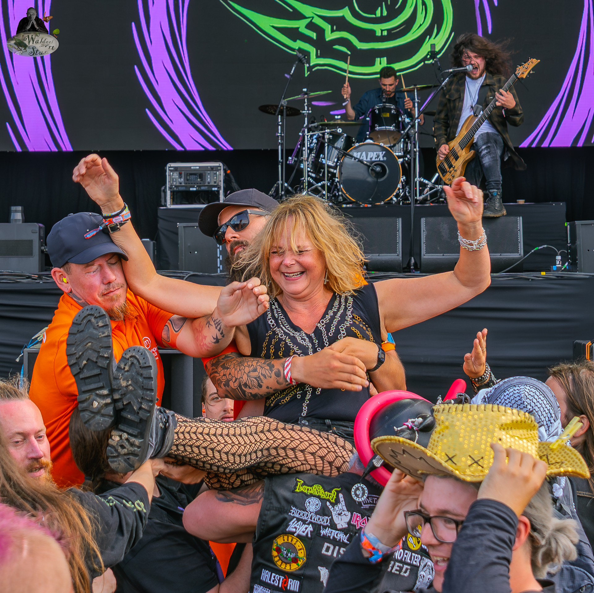Female crowd surfer smiling as she is lifted by the audience in front of the stage during Shrapnel’s performance at Bloodstock Open Air Festival