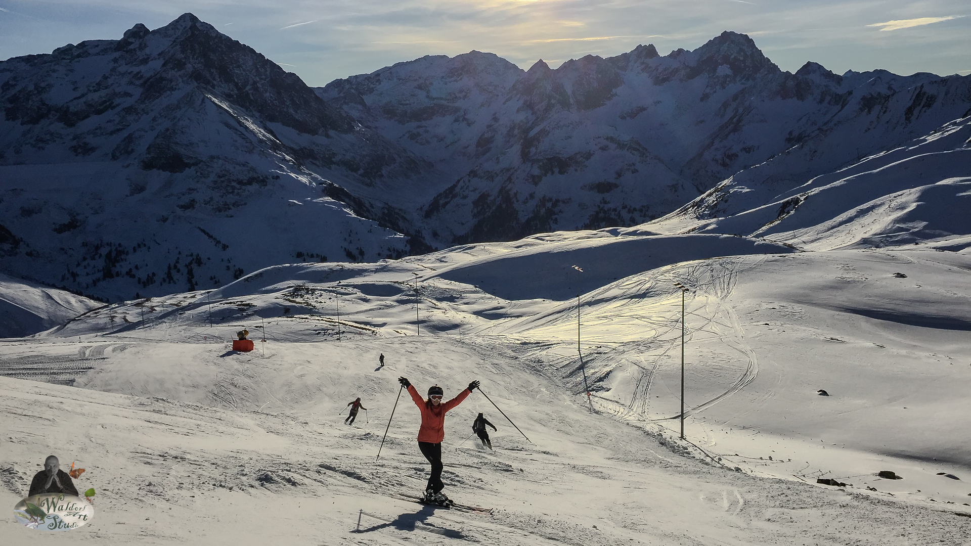 Skier celebrating on a snowy alpine slope with dramatic mountain peaks in the background during winter
